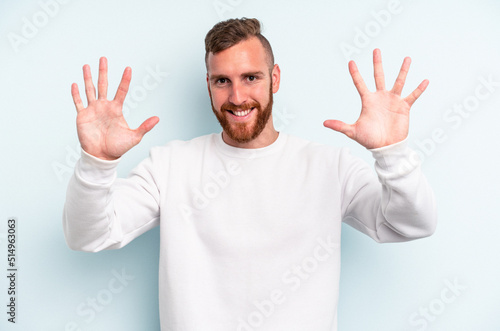 Young caucasian man isolated on blue background showing number ten with hands. © Asier