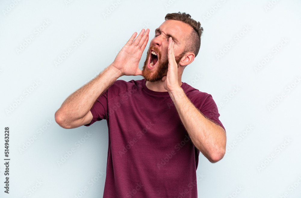Young caucasian man isolated on blue background shouting excited to front. Young caucasian man isolated on blue background shouting excited to front.