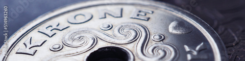 1 Danish krone coin close-up. National currency of Denmark. Blue tinted money banner. Header for news about economy or finance. Bank and loan. Savings and interest. Macro