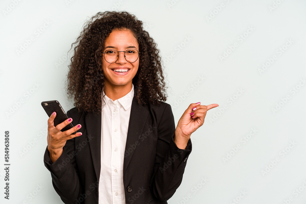 Young business Brazilian woman holding mobile phone isolated on white background smiling and pointing aside, showing something at blank space. Young business Brazilian woman holding mobile phone isolated on white background smiling and pointing aside, showing something at blank space.
