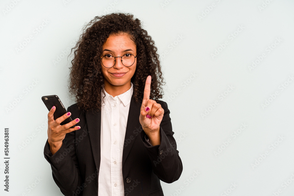 Young business Brazilian woman holding mobile phone isolated on white background showing number one with finger. Young business Brazilian woman holding mobile phone isolated on white background showing number one with finger.