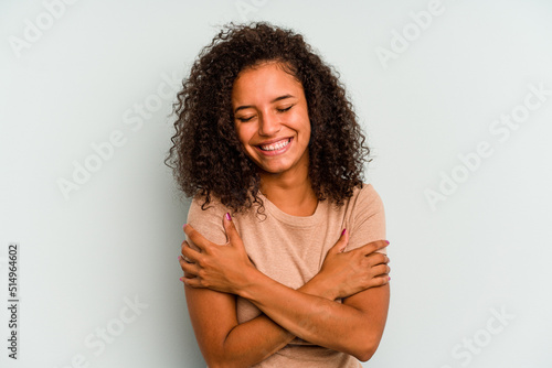 Young Brazilian woman isolated on blue background laughing and having fun.