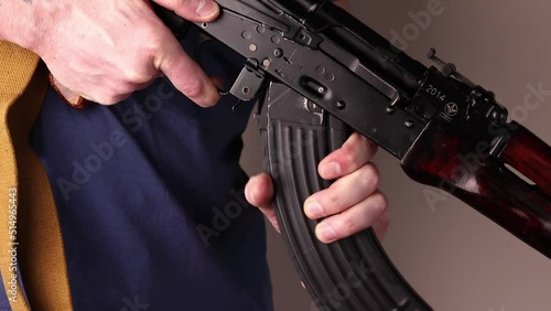 Man detaches ak-47 magazine with cartridges and unloads Kalashnikov assault rifle