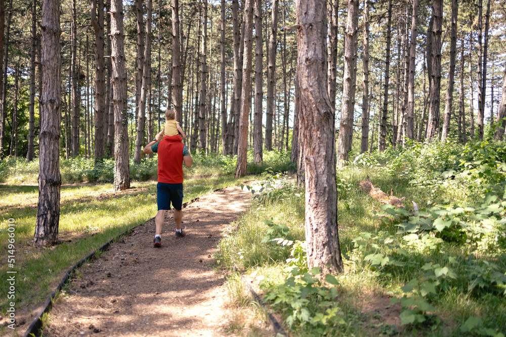 Caucasian father and his baby girl going on a hike, shot from behind Caucasian father and his baby girl going on a hike, shot from behind