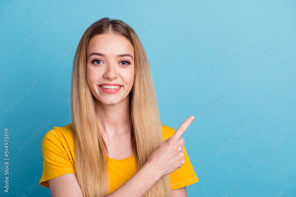Photo of sweet young woman dressed shirt smiling pointing back finger empty space isolated blue color background Photo of sweet young woman dressed shirt smiling pointing back finger empty space isolated blue color background