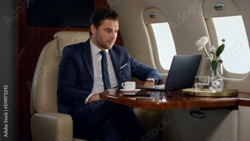 Принти на полотні Serious businessman videocalling partner in private jet