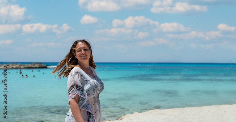 Woman with a smile on her face enjoys a beautiful beach.New summer season.With copy space