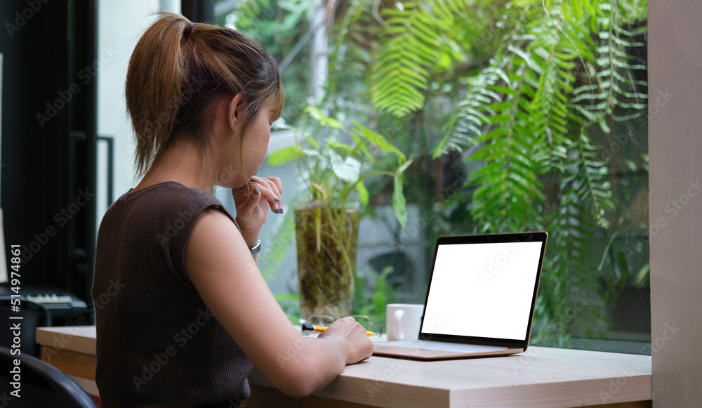 Woman working from home on laptop while sitting at the living room.. Woman working from home on laptop while sitting at the living room..