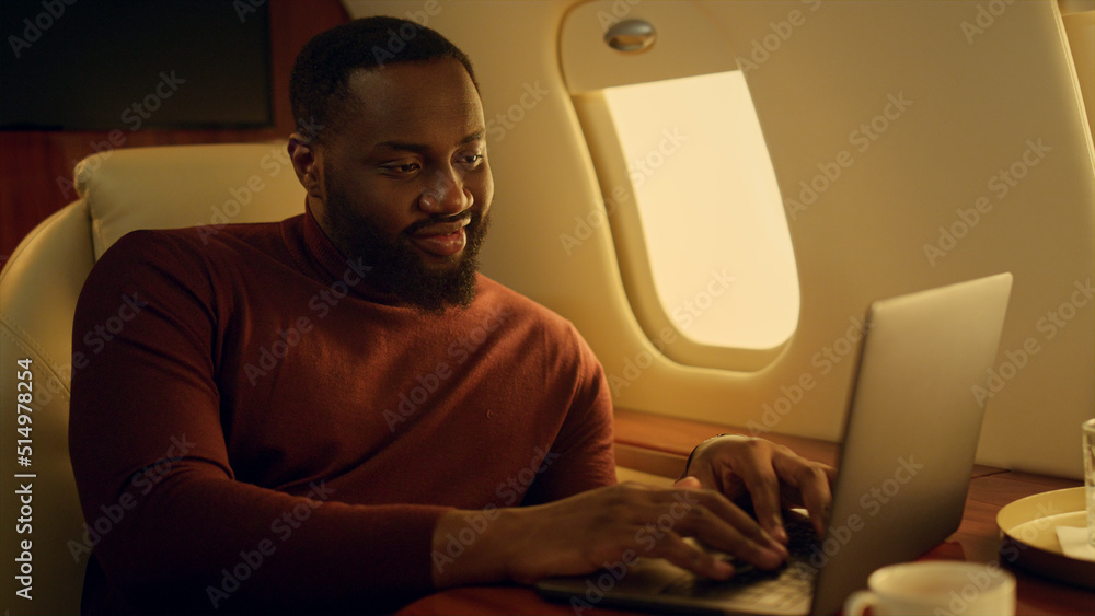 Cheerful man typing keyboard on business travel closeup. African american work Cheerful man typing keyboard on business travel closeup. African american work