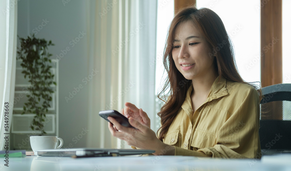 Asian female employees checking social media, reading online news on her smart phone.