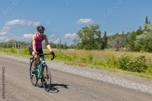Fototapeta Naklejka Na Ścianę i Meble -  woman cycling on gravel road