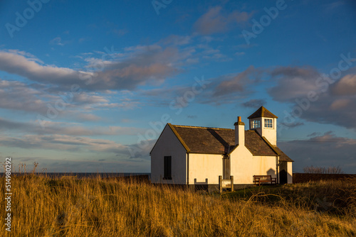The old Watch House on the cliffs above Seaton Sluice in Northumberland, England at sunset.