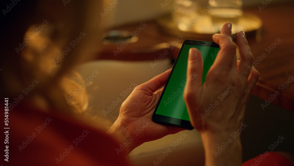 Lady using green smartphone on corporate trip closeup. Hand scroll mockup screen