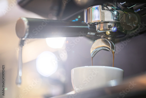 Coffee extraction from coffee machine to white cup in coffee shop. Food and beverage concept