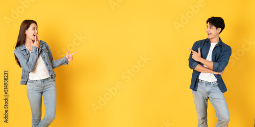 Two Young good looking asian couple using isolated on yellow background presenting to copy space