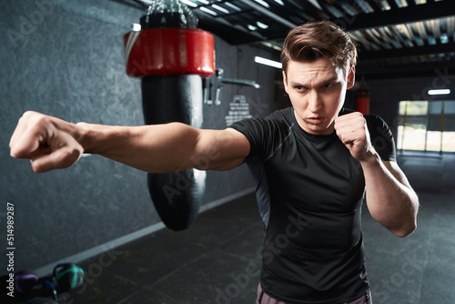 Professional sportsman shadow-boxing during gym training session