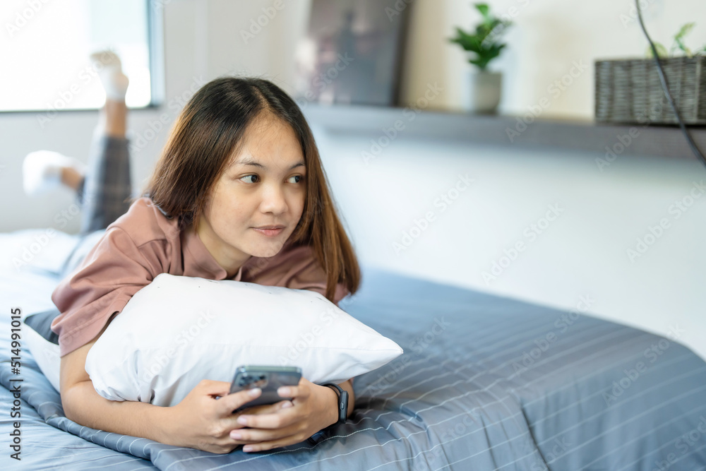 medium shot A teenage long-haired Asian woman lies on the bed in her bedroom. She had a phone in her hand and was chatting happily with her friends online. medium shot A teenage long-haired Asian woman lies on the bed in her bedroom. She had a phone in her hand and was chatting happily with her friends online.