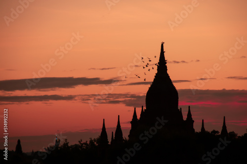 Sunset on a view of Thatbyinnyu temple pagoda in old Bagan  Myanmar with bird flying in the sky