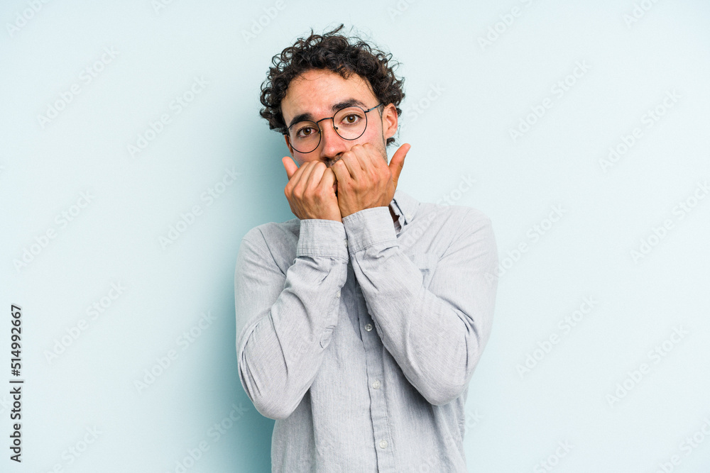 Young caucasian man isolated on blue background biting fingernails, nervous and very anxious. Young caucasian man isolated on blue background biting fingernails, nervous and very anxious.
