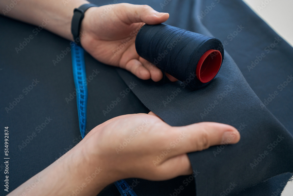 Designer checks the shade of the threads with the fabric Designer checks the shade of the threads with the fabric