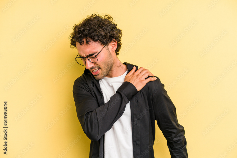 Young caucasian man isolated on yellow background having a shoulder pain. Young caucasian man isolated on yellow background having a shoulder pain.