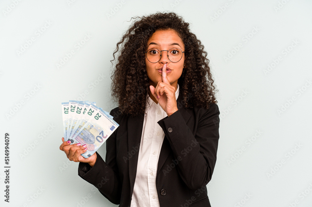 Young business Brazilian woman holding banknotes isolated on white background keeping a secret or asking for silence. Young business Brazilian woman holding banknotes isolated on white background keeping a secret or asking for silence.