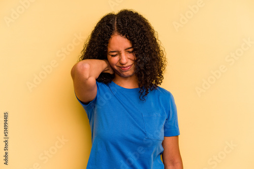 Young Brazilian woman isolated on yellow background suffering neck pain due to sedentary lifestyle.
