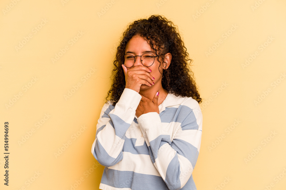 Young Brazilian woman isolated on yellow background suffers pain in throat due a virus or infection. Young Brazilian woman isolated on yellow background suffers pain in throat due a virus or infection.