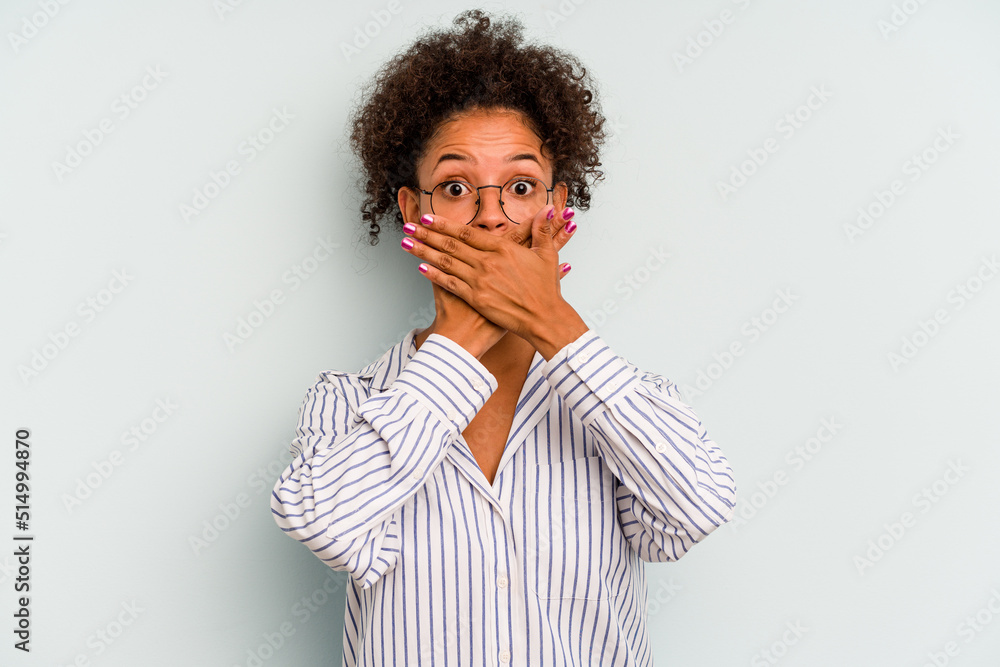 Young Brazilian woman isolated on blue background shocked covering mouth with hands.