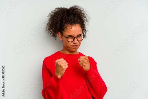 Young Brazilian woman isolated on blue background showing fist to camera, aggressive facial expression.