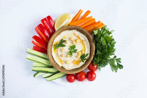 Принти на полотні Top view of hummus in the brown bowl and vegetable on the white background