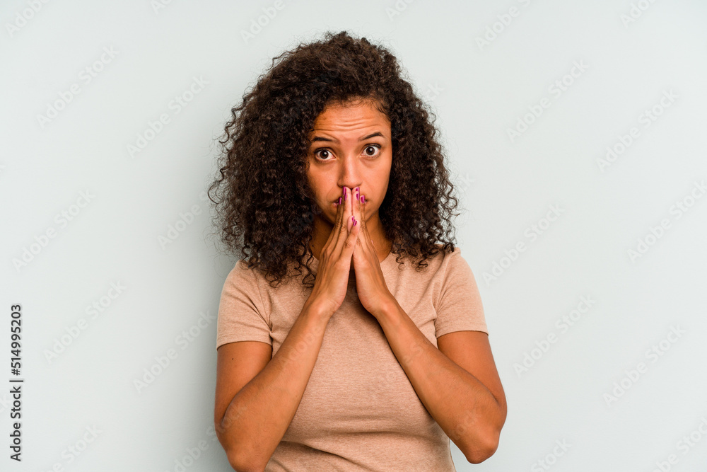 Young Brazilian woman isolated on blue background covering mouth with hands looking worried. Young Brazilian woman isolated on blue background covering mouth with hands looking worried.