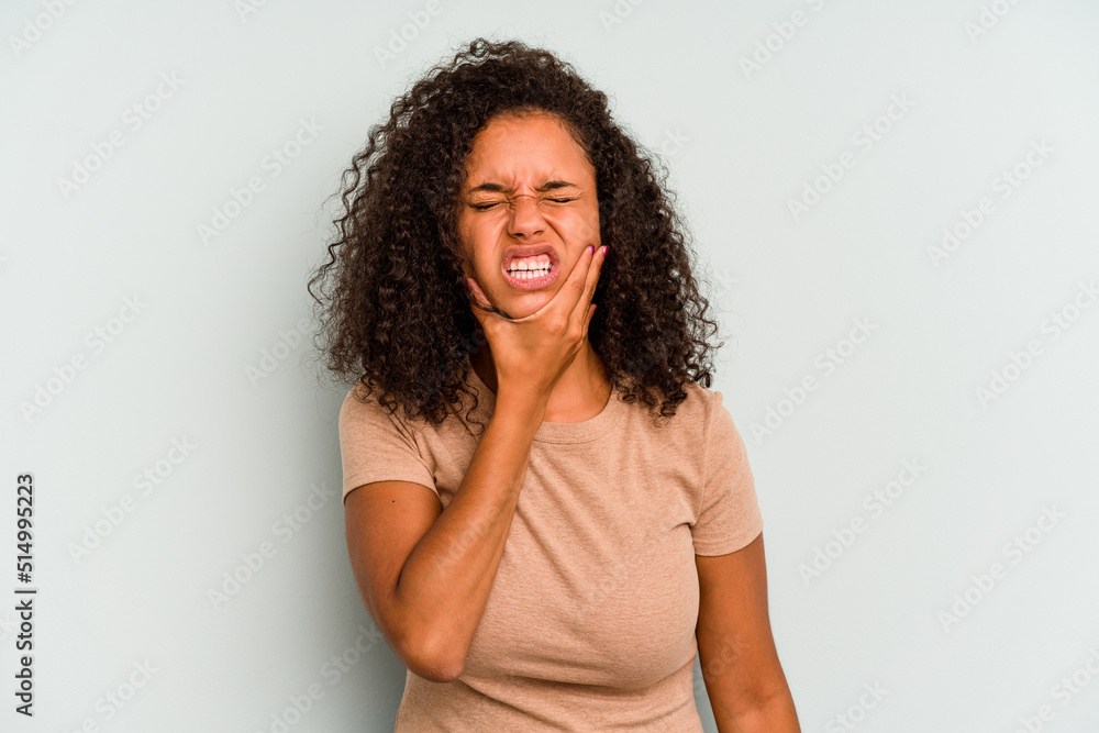Young Brazilian woman isolated on blue background having a strong teeth pain, molar ache. Young Brazilian woman isolated on blue background having a strong teeth pain, molar ache.