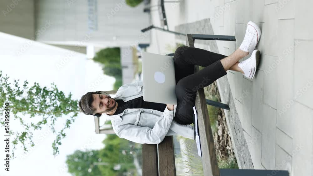 Vertical video of business man wearing headphones communicating by video call. Ethnic businessman speaking looking at laptop computer, online conference distance office chat, virtual training concept Vertical video of business man wearing headphones communicating by video call. Ethnic businessman speaking looking at laptop computer, online conference distance office chat, virtual training concept