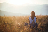 Beautiful Teen Girl sitting in Mountain Golden Field
