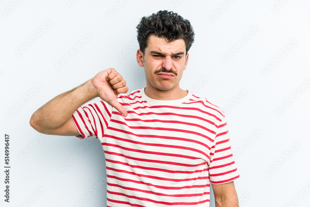 Young caucasian man isolated on blue background showing thumb down, disappointment concept. Young caucasian man isolated on blue background showing thumb down, disappointment concept.