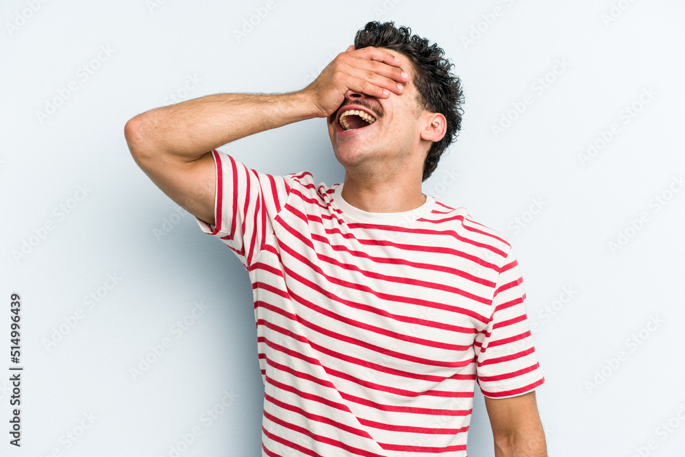 Young caucasian man isolated on blue background laughs joyfully keeping hands on head. Happiness concept. Young caucasian man isolated on blue background laughs joyfully keeping hands on head. Happiness concept.