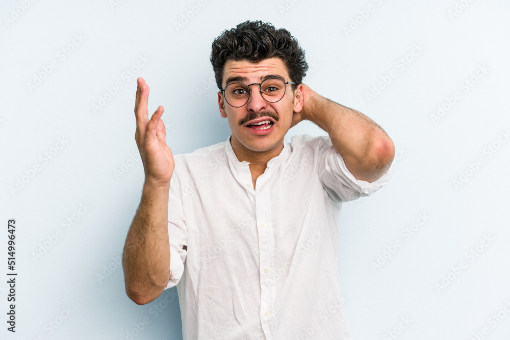 Naklejka premium Young caucasian man isolated on blue background screaming with rage.