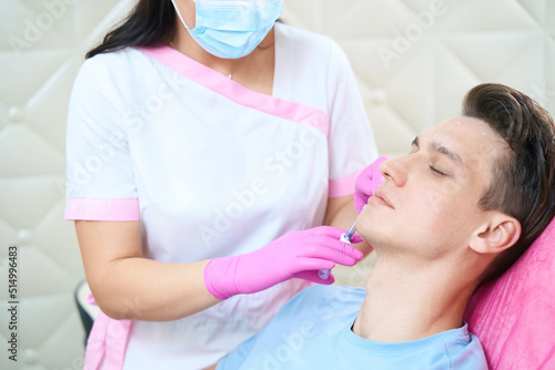 Calm man during anti wrinkles procedures in beauty clinic