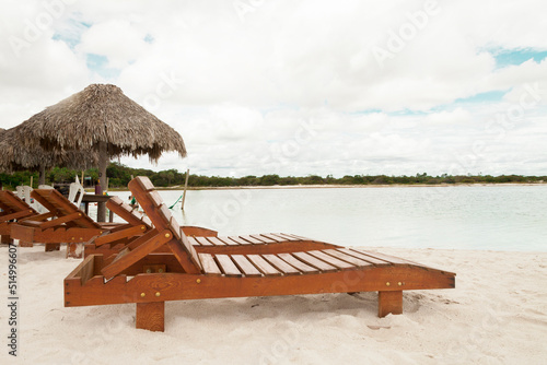 Deckchair lounger on the edge of the beach in summer with nice tropical weather. Resort by the sea in Brazil. Beach chair concept. Tourism concept. Copy space.