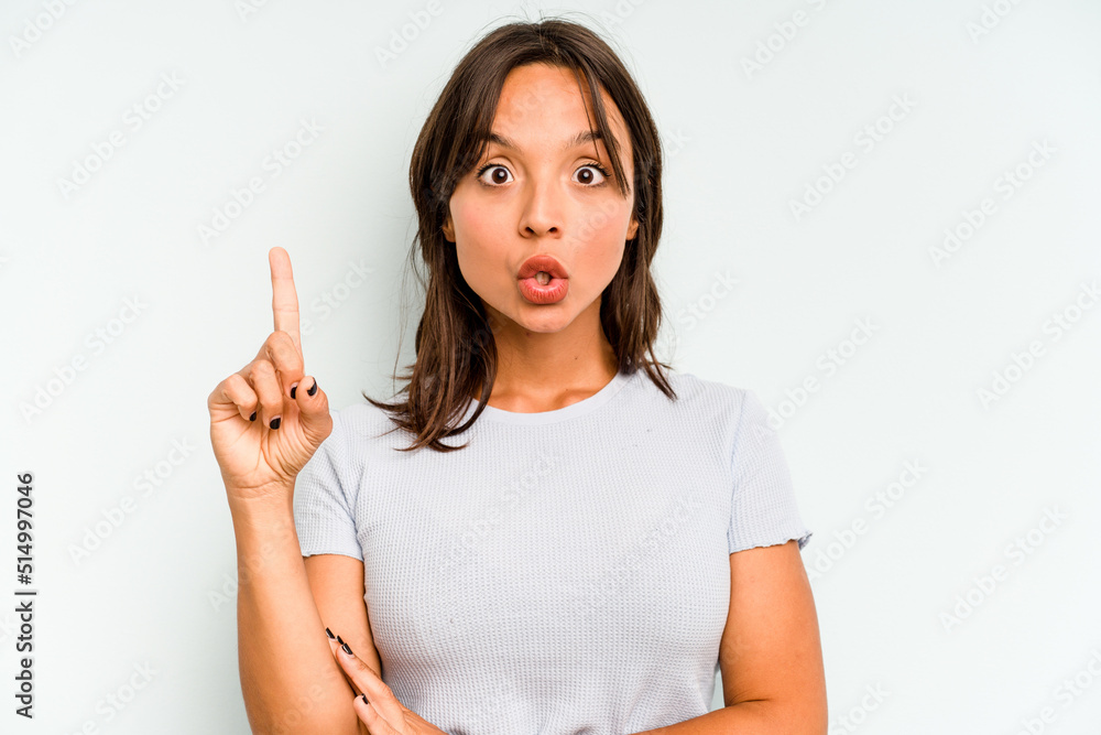 Young hispanic woman isolated on blue background showing a copy space on a palm and holding another hand on waist. Young hispanic woman isolated on blue background showing a copy space on a palm and holding another hand on waist.