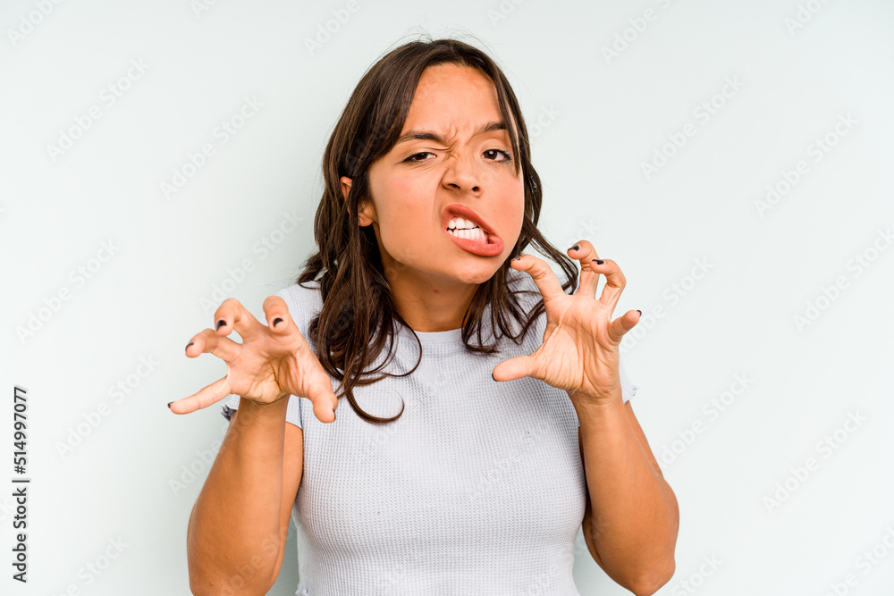 Young hispanic woman isolated on blue background holding hands in pray near mouth, feels confident. Young hispanic woman isolated on blue background holding hands in pray near mouth, feels confident.