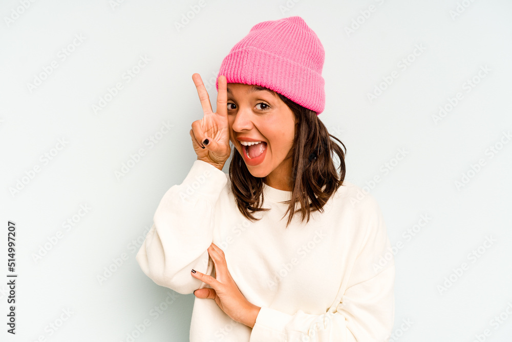 Young hispanic woman isolated on blue background shocked and amazed holding a copy space between hands. Young hispanic woman isolated on blue background shocked and amazed holding a copy space between hands.