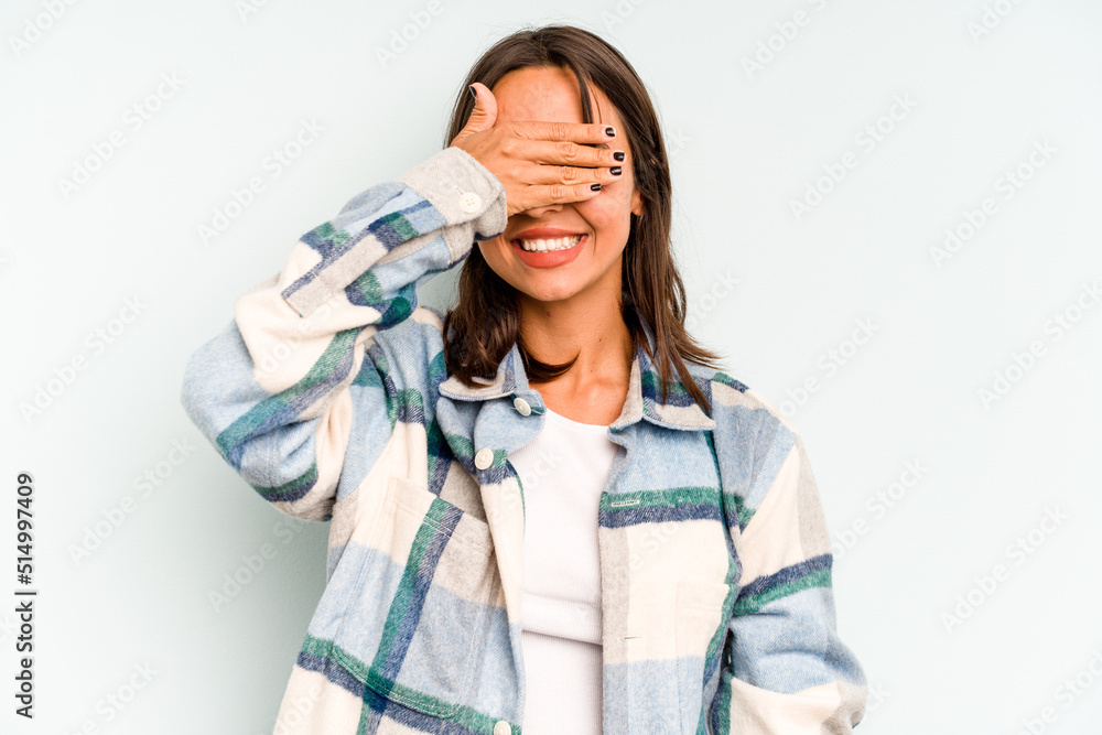 Young hispanic woman isolated on blue background laughs happily and has fun keeping hands on stomach. Young hispanic woman isolated on blue background laughs happily and has fun keeping hands on stomach.