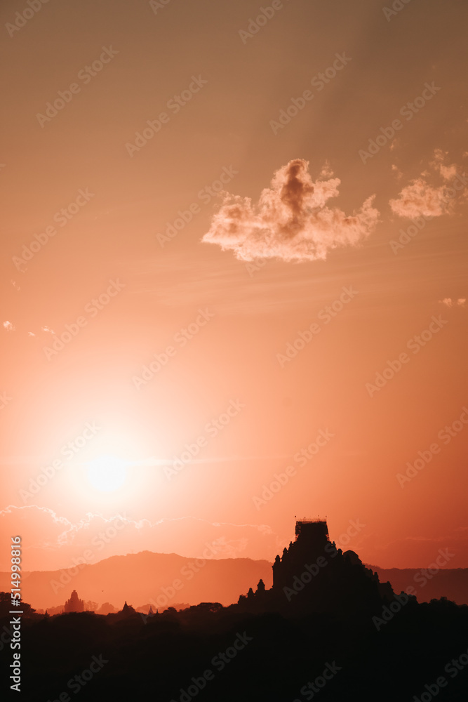 Sunrise on a view of a temple ruin in old Bagan with clouds in the sky, Myanmar, vertical photo