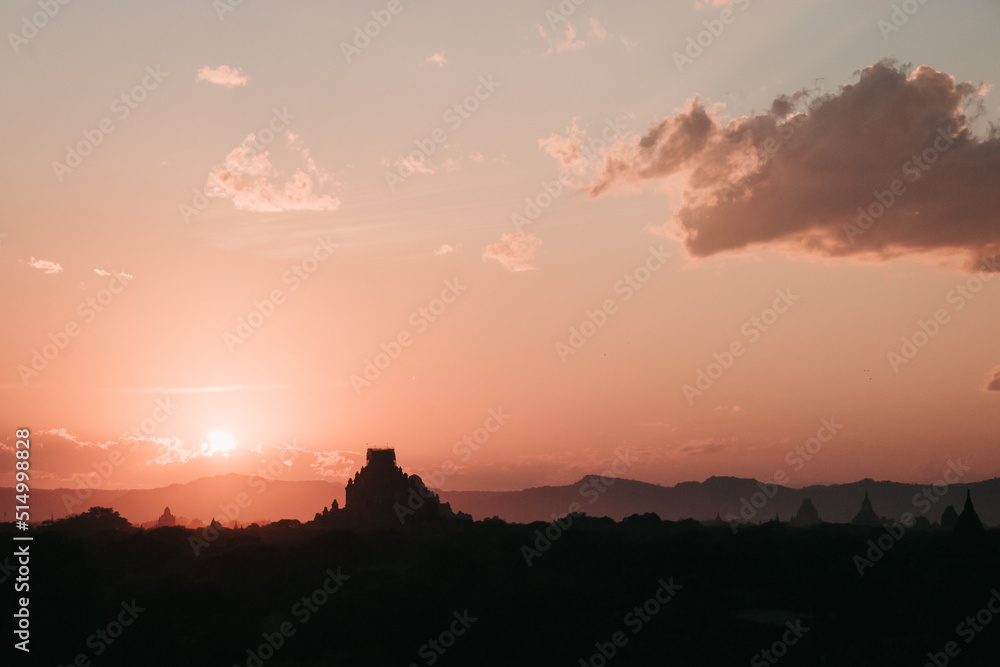 Sunrise on a view of a temple ruin in old Bagan with clouds in the sky, Myanmar
