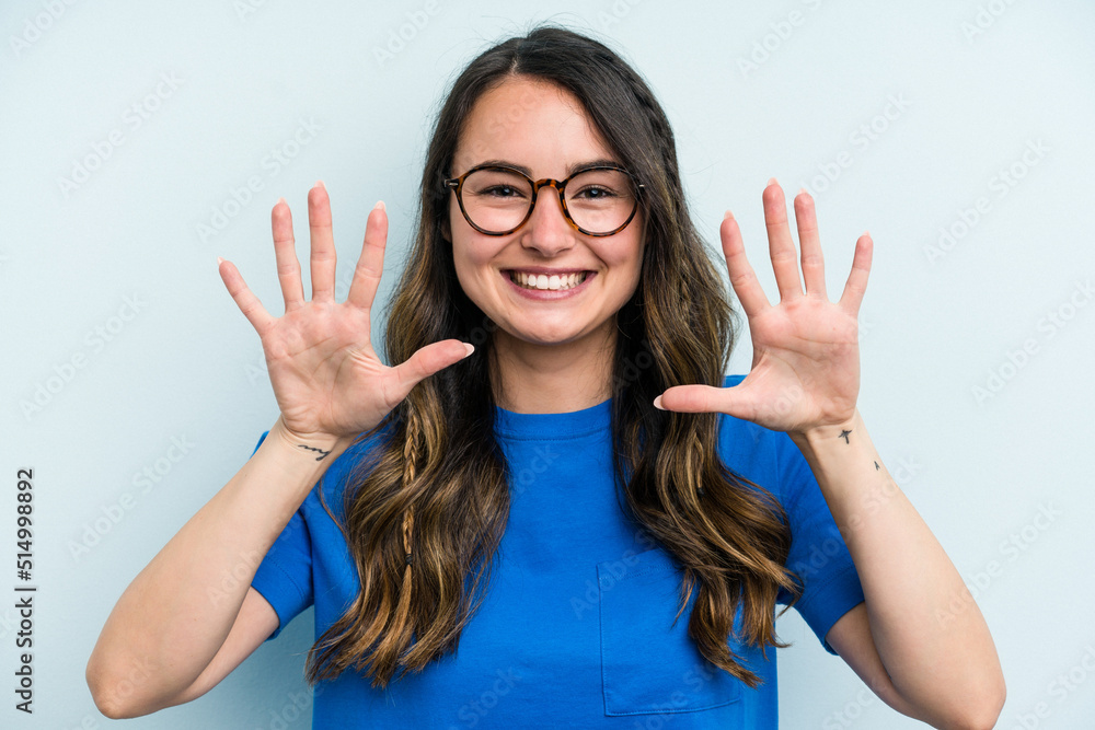 Young caucasian woman isolated on blue background showing number ten with hands. Young caucasian woman isolated on blue background showing number ten with hands.