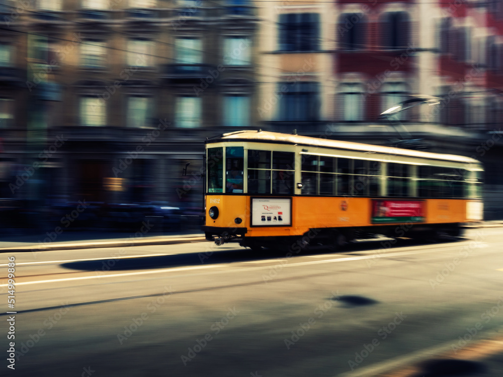 Panning photo of a Yellow tram car in Milan 