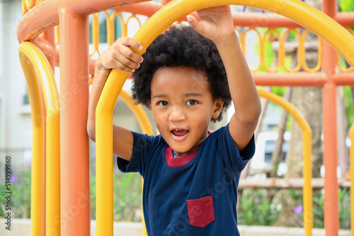 Cute African American boy having fun while playing on the playground on sunny day. Five years old. Outdoor activity.