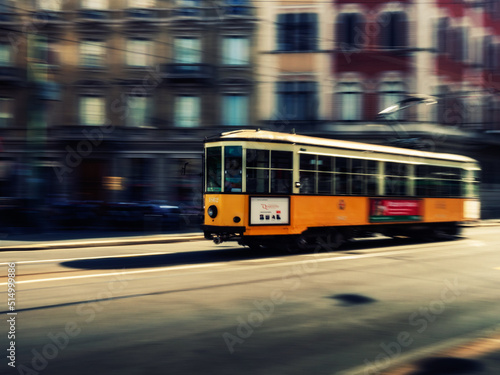 Panning photo of a Yellow tram car in Milan 